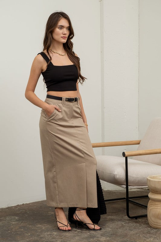 model is wearing Black Solid Square Neck Tank with beige  beige maxi skirt with black lace up heels 