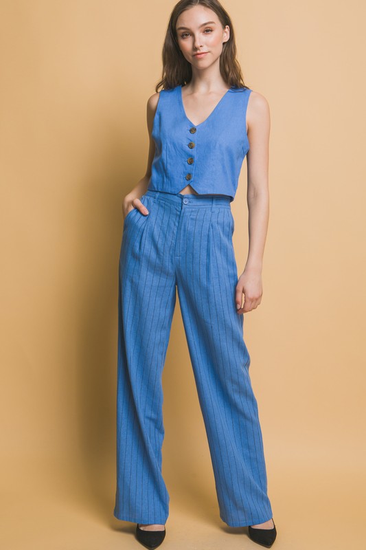 model is wearing Blue Linen Buttoned Vest Top with matching pants and black heels 