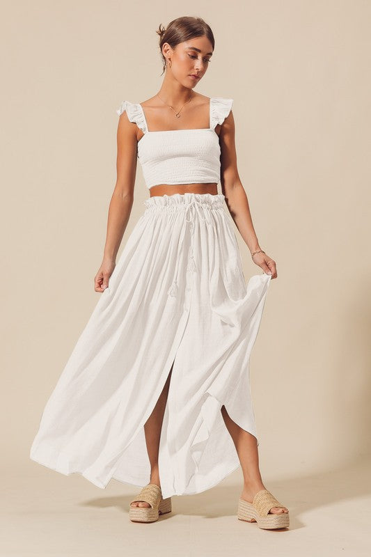 model is wearing Off White Smocked Flowy Maxi Skirt Set with straw platform sandals 