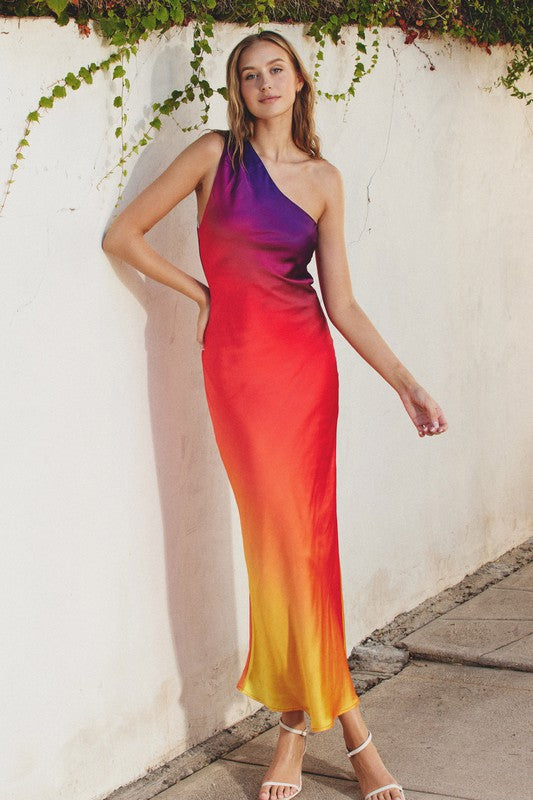 Model is wearing Sunset One Shoulder Maxi Dress with white sandals 