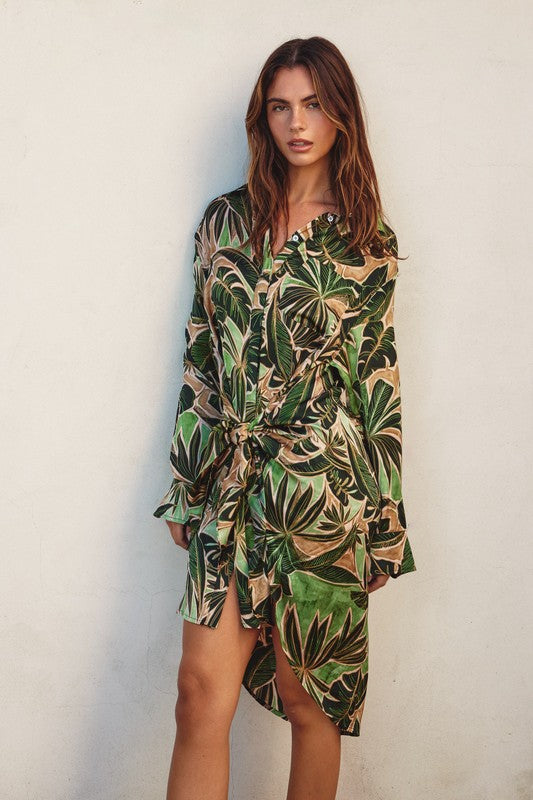 Model is wearing Green Tropical Tie Shirt Dress long sleeve dress with a front tie 