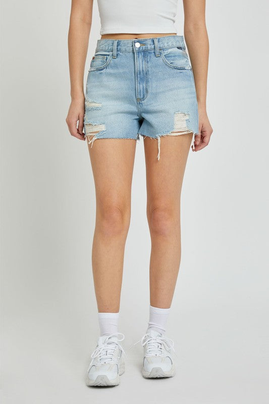 model is wearing Light Denim High Rise Mom Shorts with white top and white running sneakers