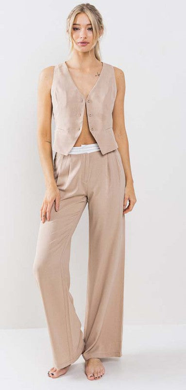 model is wearing taupe vest set with matching pants