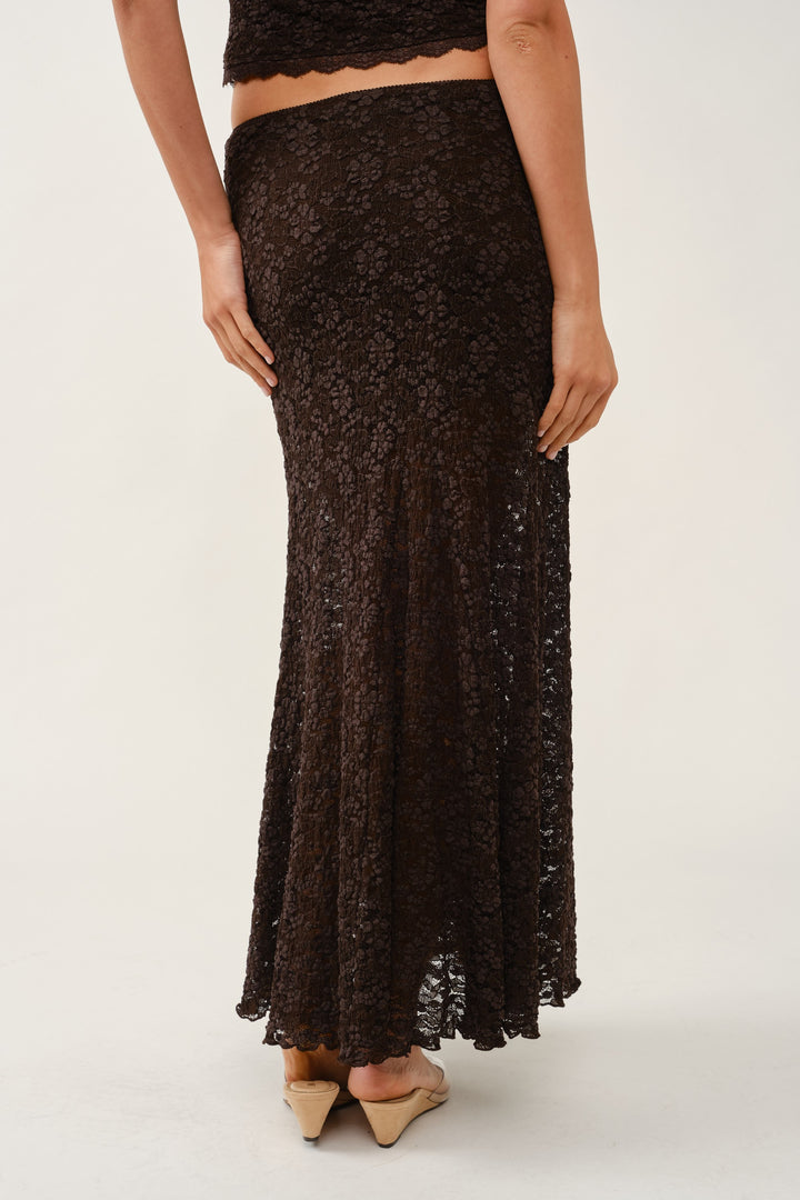 Side detail of the brown floral lace maxi skirt hem and sheer lower skirt, styled with nude heels