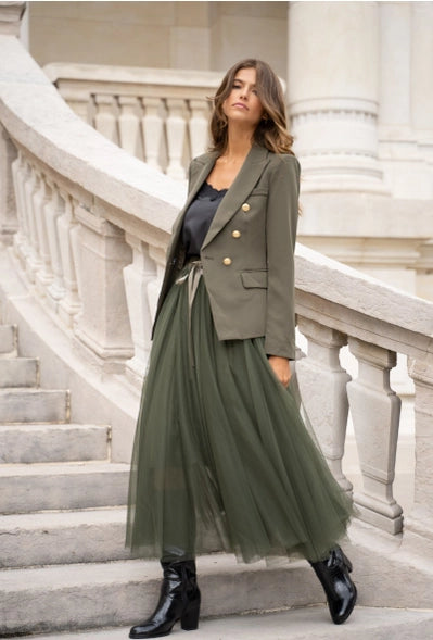 model is wearing the Khaki Fitted Blazer Jacket with a black silky top with a flowy green maxi skirt and black long cowboy boots