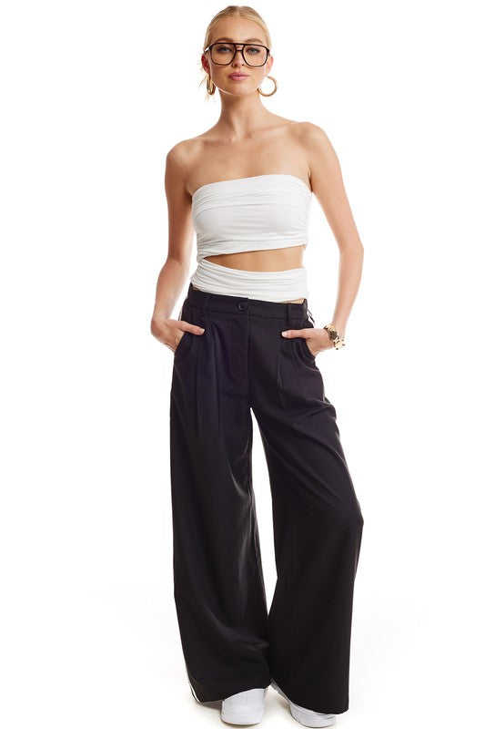 White Strapless cut out crop top with black pants with gold hoop earrings and black glasses and women's white sneakers