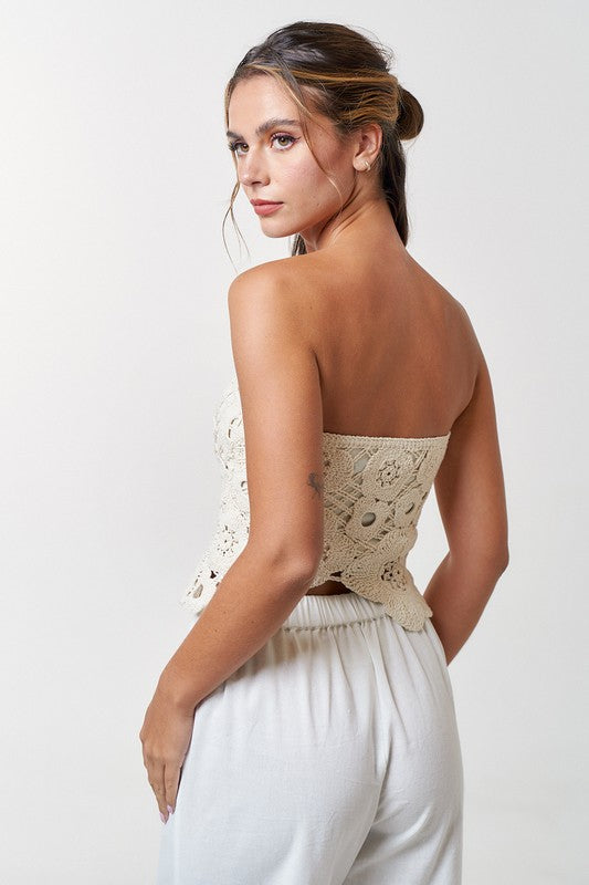 Model is wearing Natural Crochet Flyway Tube Top with white trousers. Back view of the top 