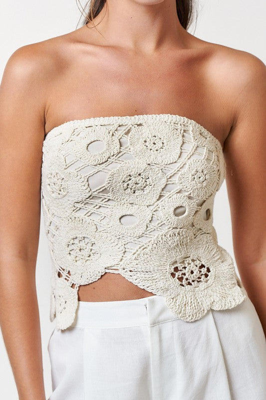 Model is wearing Natural Crochet Flyway Tube Top with white trousers. Close up view 