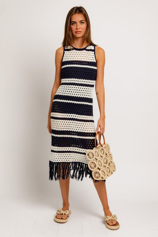 STYLED BY ALX COUTURE MIAMI BOUTIQUE Model is wearing White Navy Stripe Sleeveless Crochet Effect Sweater Dress and a crochet handbag and sandals 