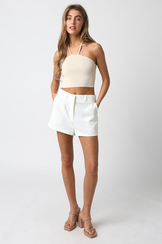 model is wearing White Lily Shorts and beige top with beige sandals 