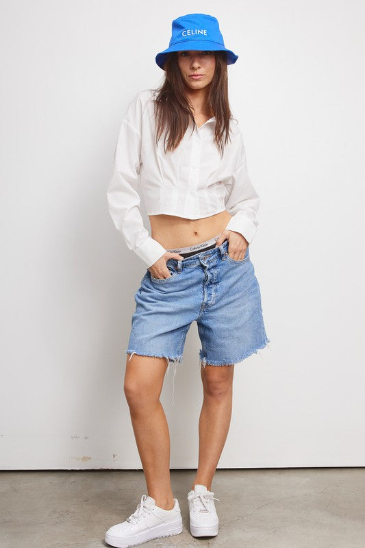 model is wearing White Giselle Shirt with a blue bucket hat and denim short and white sneakers