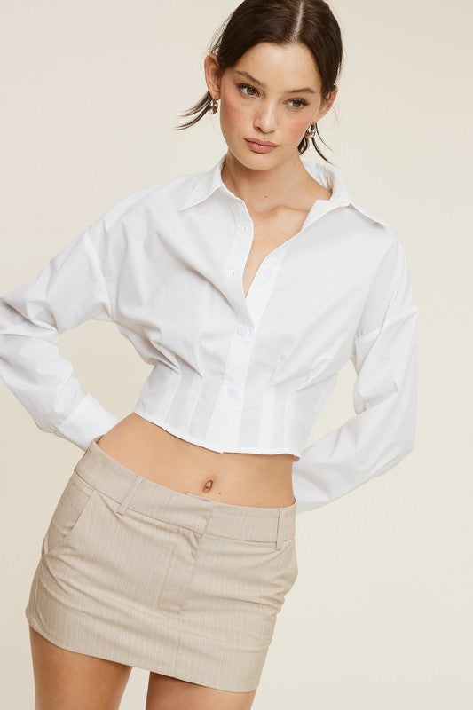Model is wearing White Giselle Long Sleeve Shirt with a mini Beige striped skirt