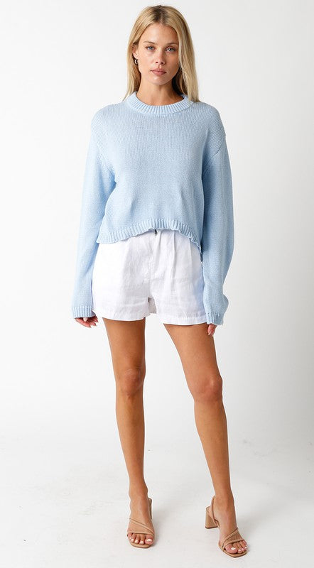 STYLED BY ALX COUTURE MIAMI BOUTIQUE Model is wearing White Jolie Shorts with beige heels and a baby blue sweater 