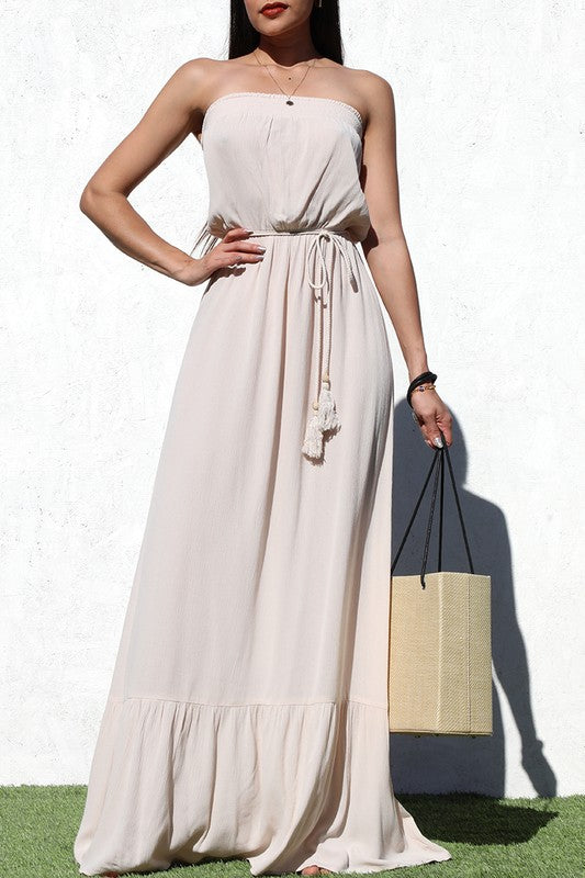 model is wearing Taupe Tube Maxi Dress with a natural straw tote bag and gold necklace 