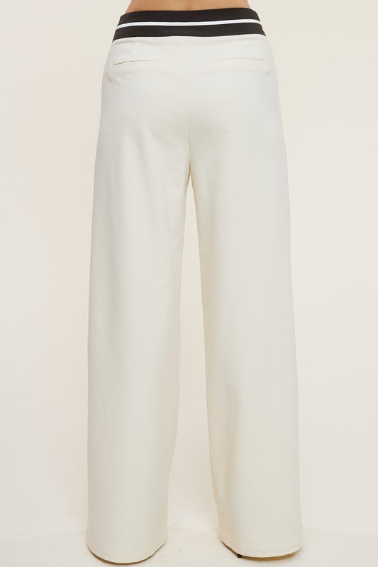 Model is wearing Cream Talbot Trousers  back view of the pants 