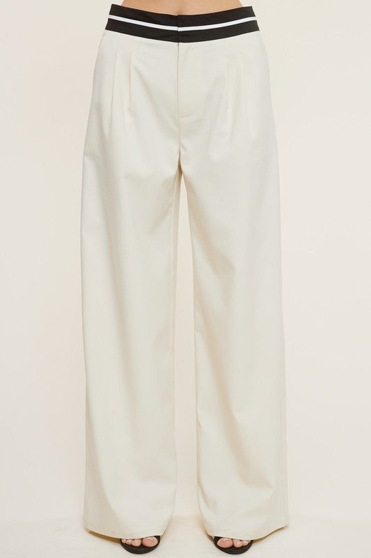 Model is wearing Cream Talbot Trousers with contrast waistband and black heels 