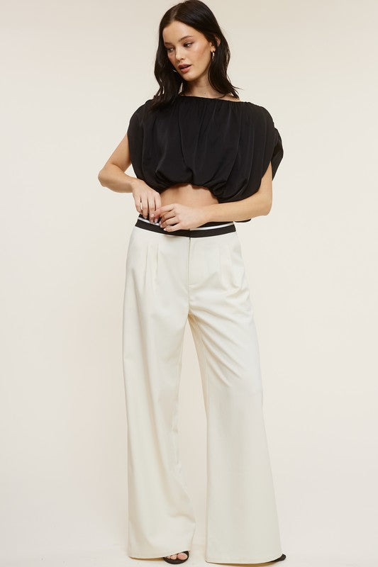 model is wearing Cream Talbot Trousers with black blouse and black heels 
