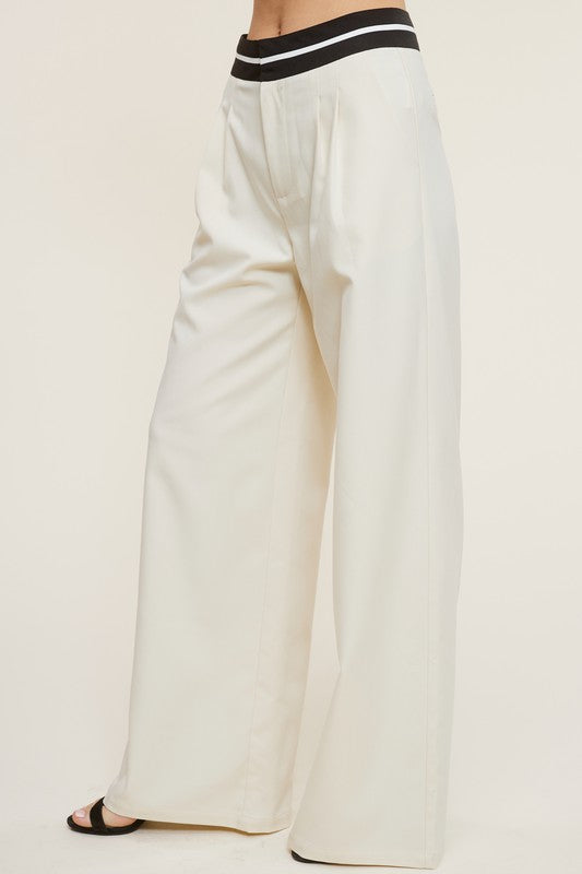Side view of the Cream Talbot Trousers with black sandals 