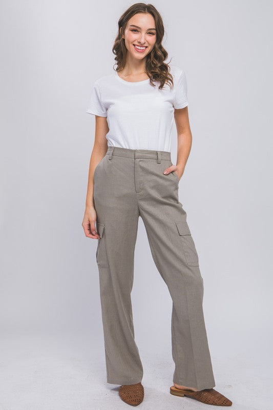 Model is wearing Greystone Linen Cargo Pants and white tshirt and camel mules 