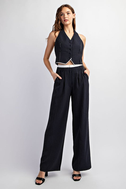 Model is wearing Navy Pinstriped Tailored Trousers with matching vest and black heels, full view of the model wearing the outfit 