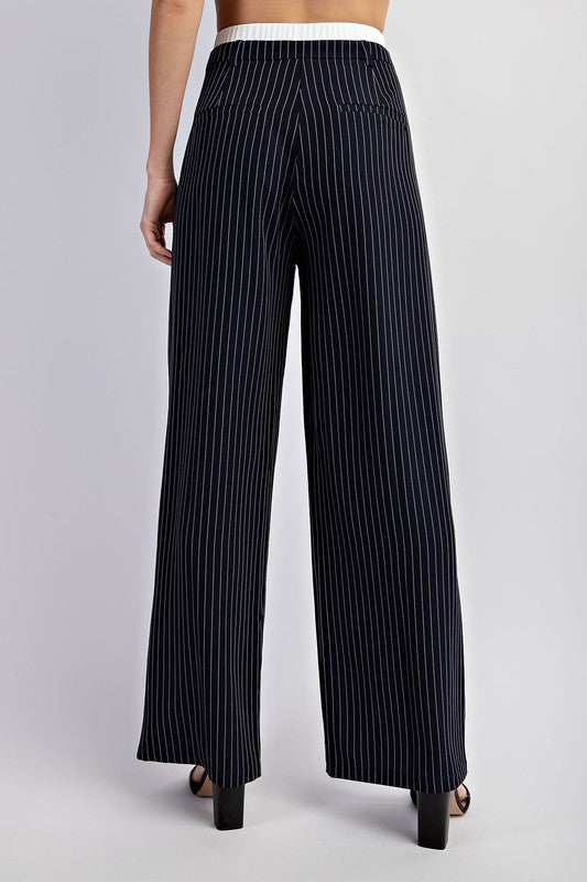 Model is wearing Navy Pinstriped Tailored Trousers, close view of the back side of the pants with black heels 