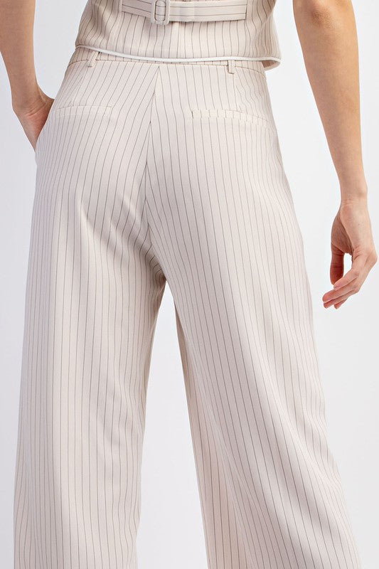 Model is wearing Beige Pinstriped Tailored Trousers  with matching vest. Close up view of the back side of the pants showing the back pockets 
