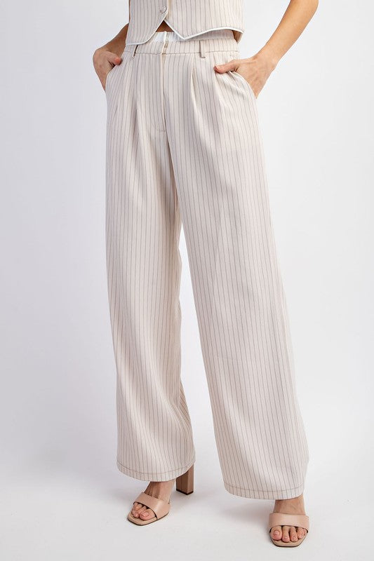 Model is wearing Beige Pinstriped Tailored Trousers with beige heels sandals . Close view of the pantts and pockets 