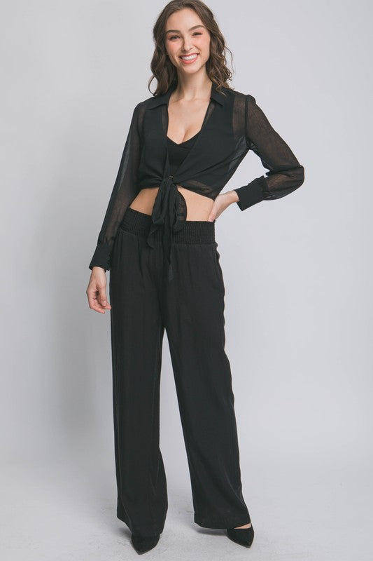 model is wearing Black Casual Elastic Waistband Pants with matching black tie top and black heels 