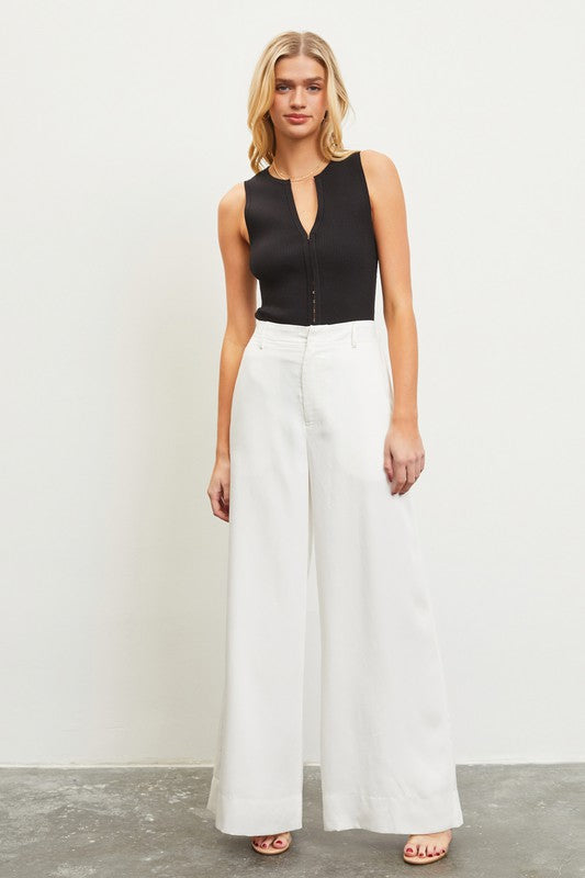model is wearing White High Waist Elastic Back Pants with a black blouse and high heels 
