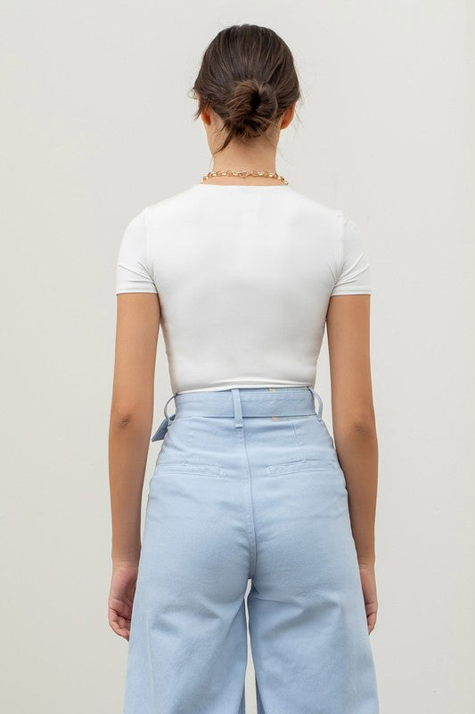 back of the White Reversible Round Neck Crop Top and blue pants
