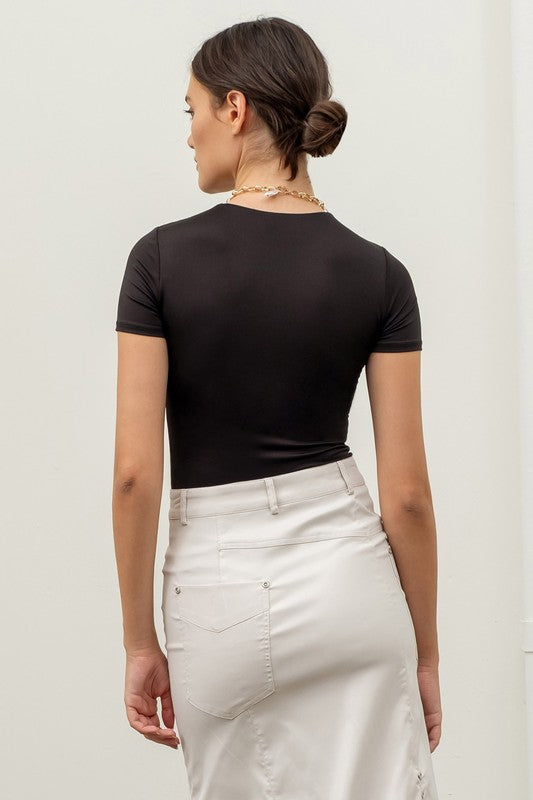 back of the model wearing Black Round Neck Bodysuit with an ivory maxi skirt 