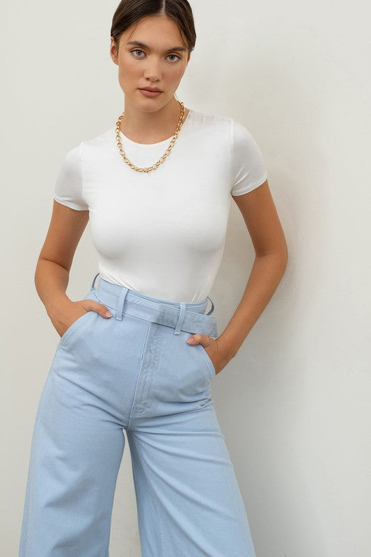 model is wearing White Round Neck Bodysuit with blue pants 