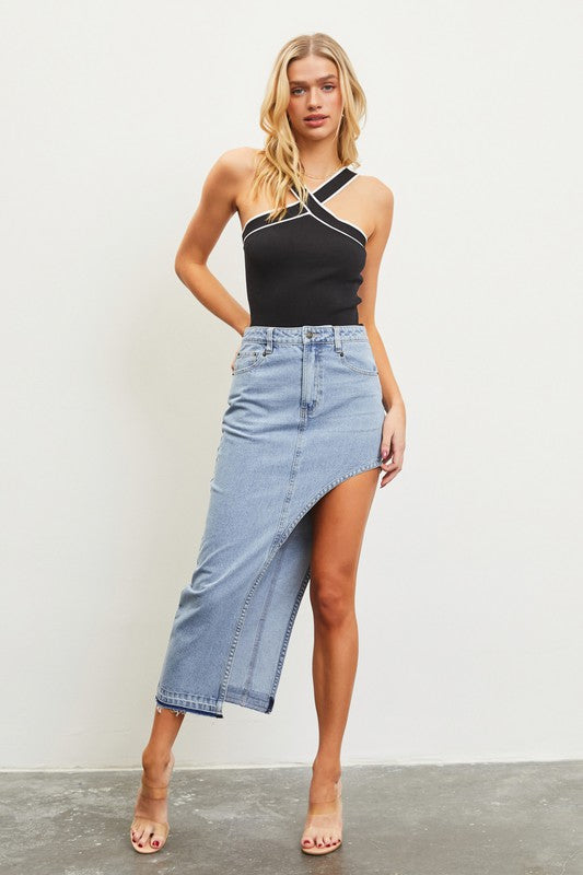 Model is wearing Washed Denim Asymmetric Maxi Skirt with a black criss cross top  and transparent high heels 