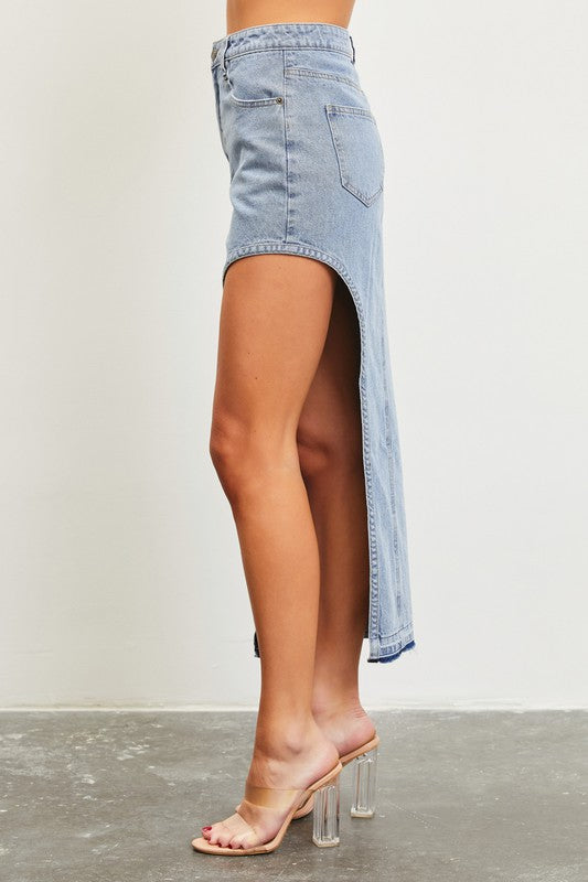 Model is wearing Washed Denim Asymmetric Maxi Skirt and transparent high heels sandals. Side view showing the leg detail 
