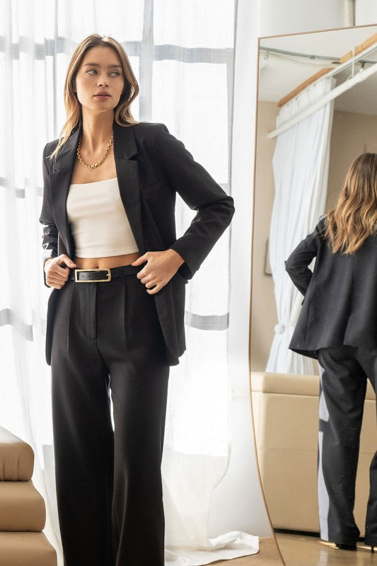 model is wearing White Square Neck Cropped Tank  with a black blazer matching black trousers and a black belt with a golden chunky necklace 