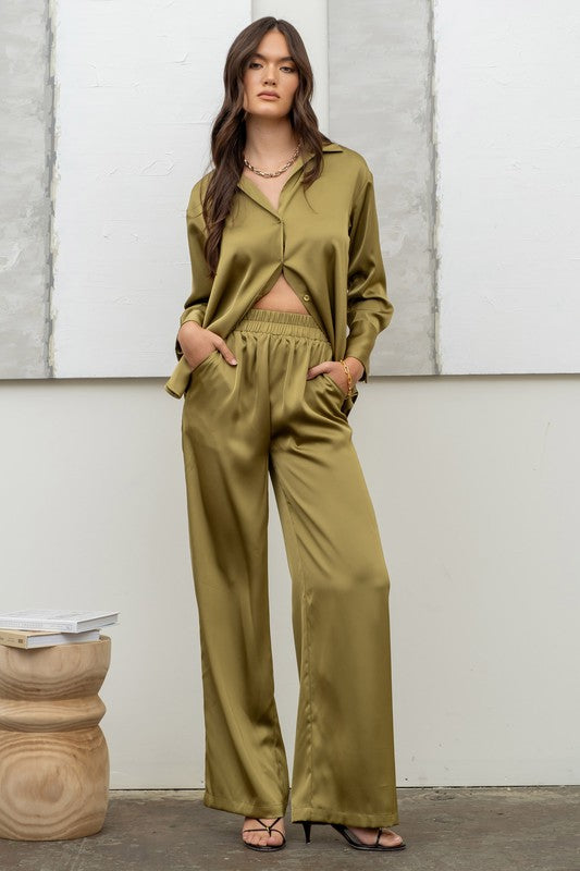 model is wearing Light Olive Satin Button Up Top with matching satin pants and black heels