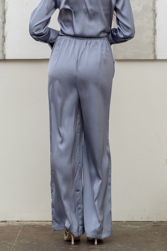 model is wearing Dusty Blue Satin Bell Bottom Pants . Back view of the pants