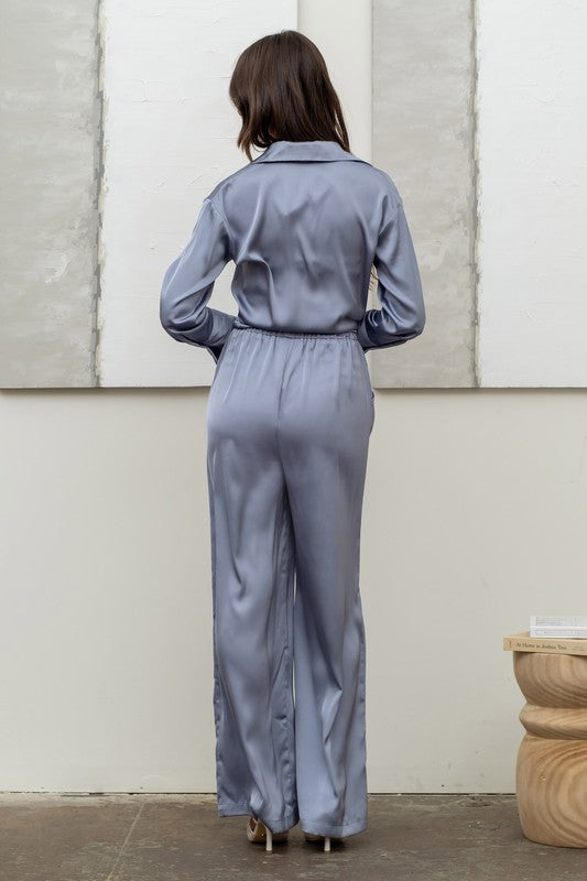 back of the model wearing Dusty Blue Satin Bell Bottom Pants  and matching satin top 