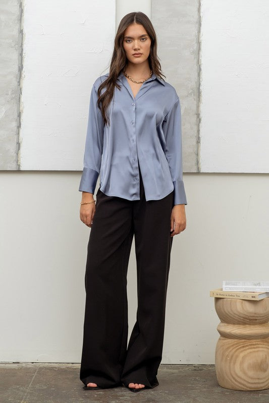 model is wearing Dusty Blue Satin Button Up Top with black pants and black heels 