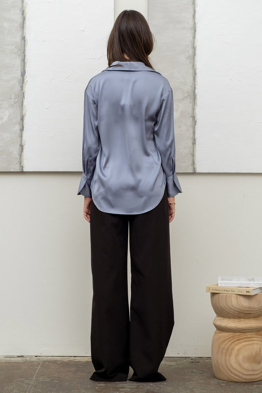 back of the model wearing the Dusty Blue Satin Button Up Top and black satin wide leg pants 
