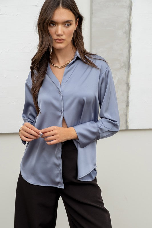 model is wearing Dusty Blue Satin Button Up Top with a black pants and chunky gold necklace 