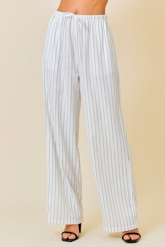 Styled by ALX COUTURE Miami boutique Model is wearing White Striped Set Linen Wide-Leg Pants with a Crop Top with black heels. Close front view of the pants 