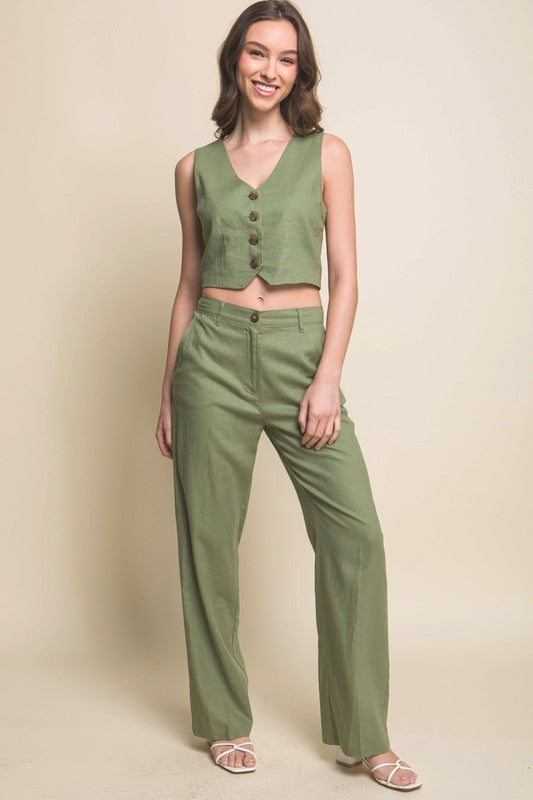 model is wearing Light Olive Linen Buttoned Vest Top with matching pants and white sandals
