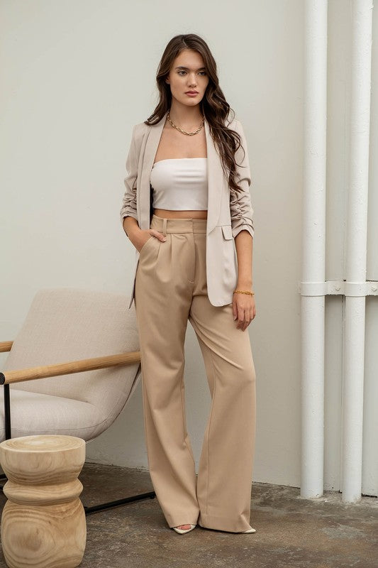 model is wearing Oatmeal Ruched Sleeve Blazer with matching trousers, white bandeu top and white heels 