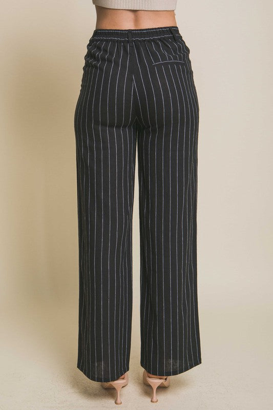 back view of the model wearing Black Linen Stripe Flannel Pants and heels