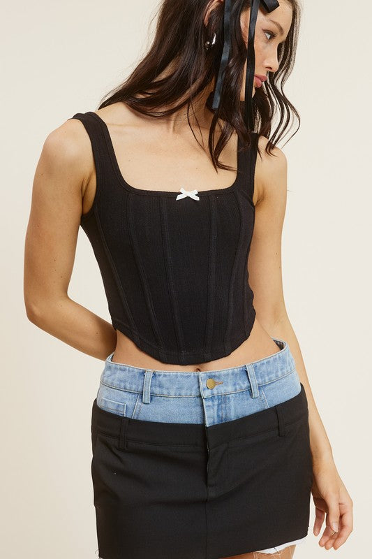Maddy Black Corset Top with small white bow in middle top with jean skirt that jean and black with white pockets coming out in the bottom
