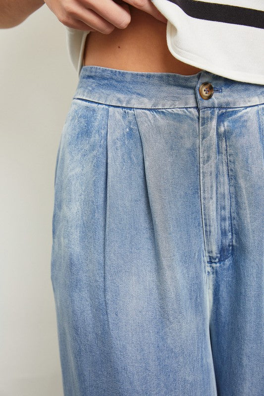 Model is wearing Denim Wide Leg Pants. Close up view of the pants detail 