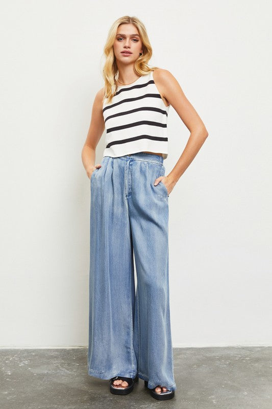 Model is wearing Denim Wide Leg Pants with a white black striped top and black sandals