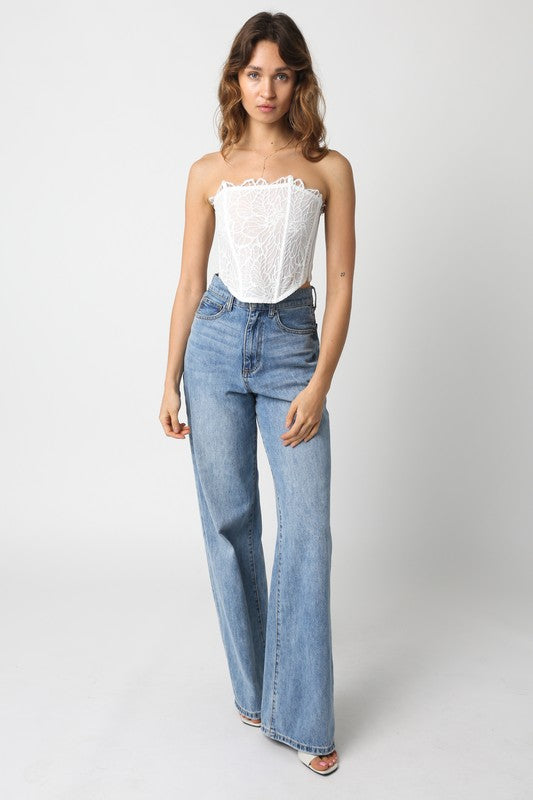 model is wearing White Zara Top and denim pants and white heels 