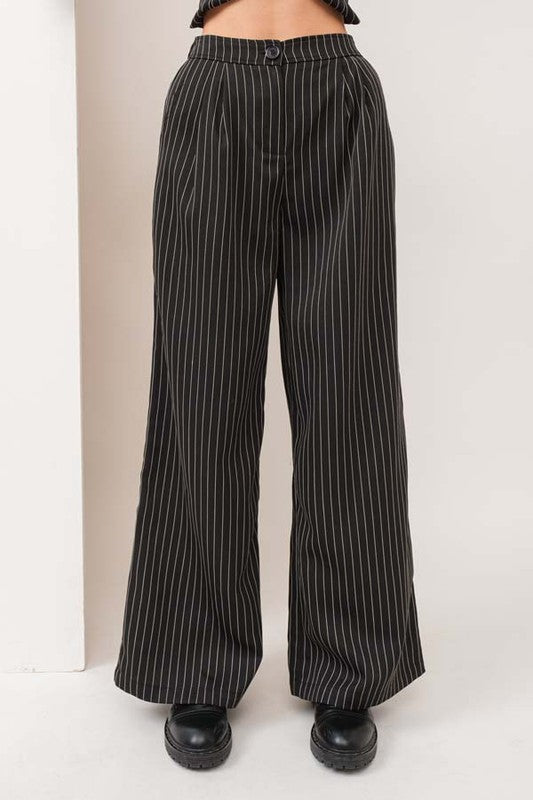 model is wearing the pants of the Black Stripe Vest Pants Set  and black boots